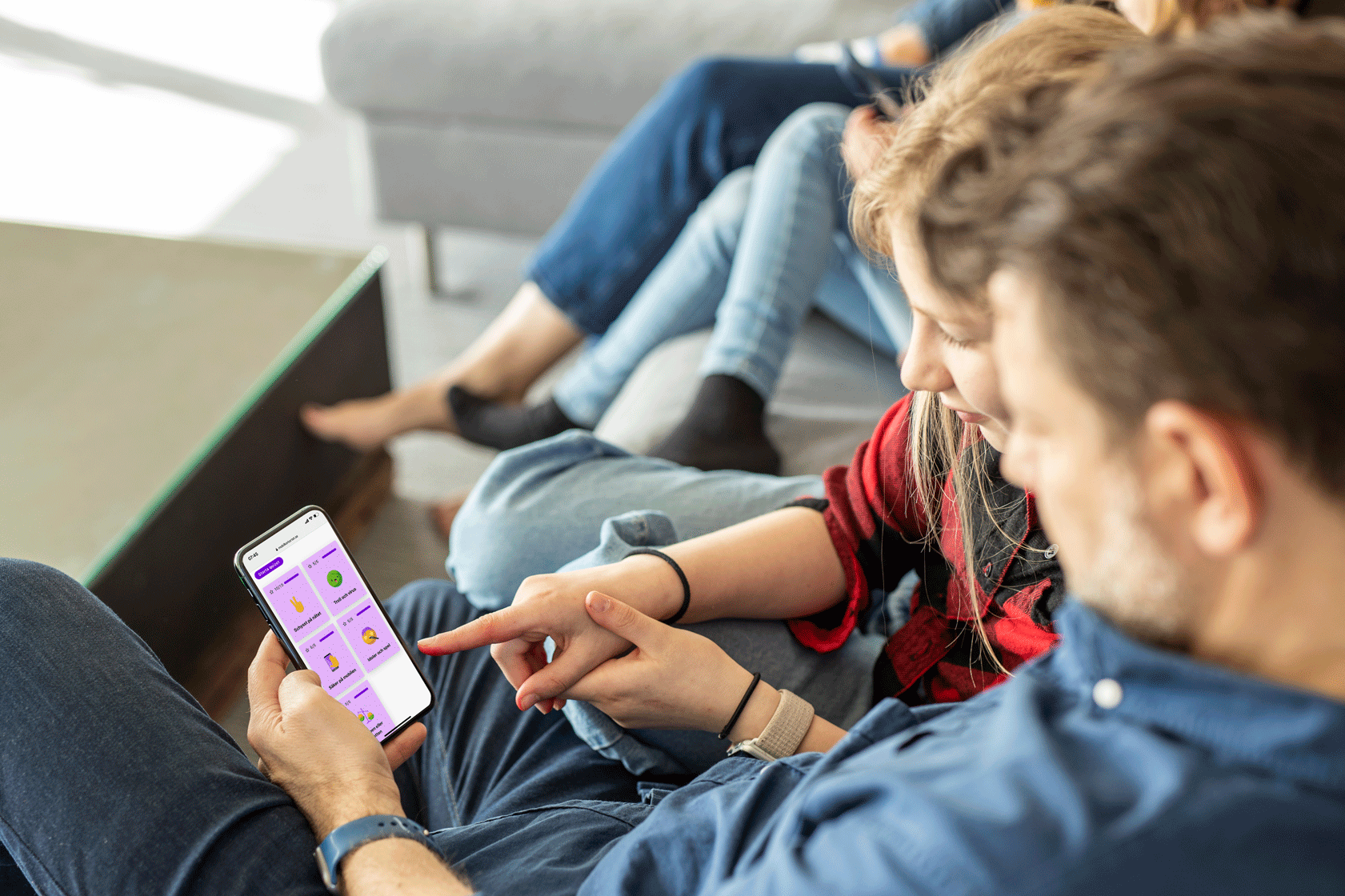 dad and daughter pointing at app on dad's smartphone